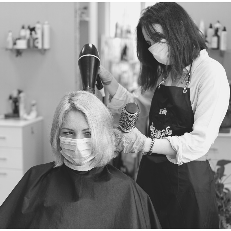 In a nursing home, on-site hair stylist with a mask