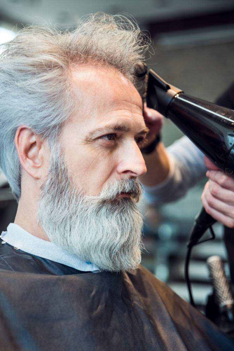 Senior man with a barber in barbershop