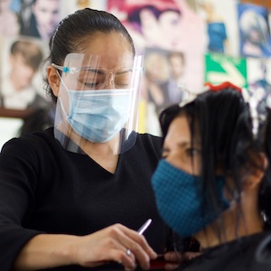 At home haircut by stylist wearing a mask